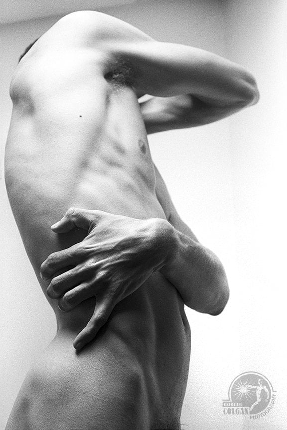 abstracted view of nude male with arms wrapped around his body