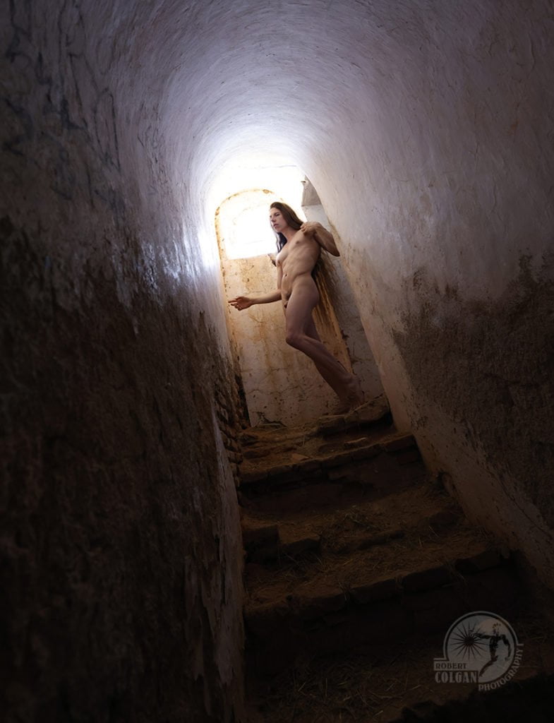 Nude man in darkened stairway