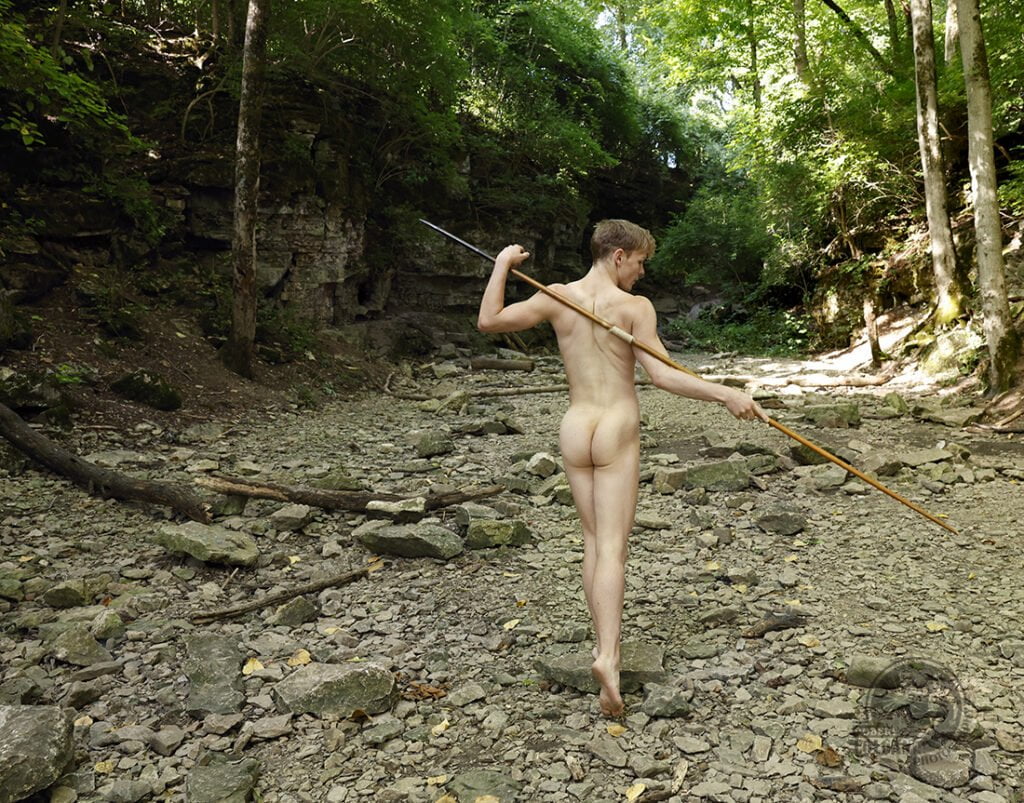 nude man walks in dry stream bed