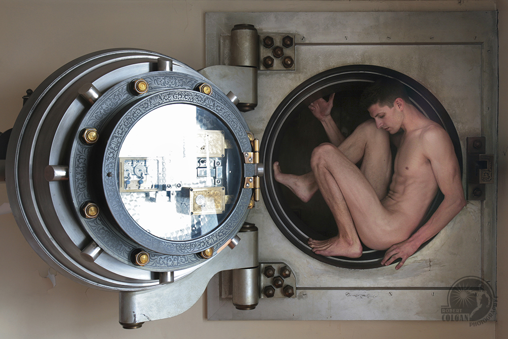 nude man curled up in bank vault