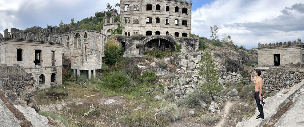 man takes picture in front of pano of abandoned radium spa