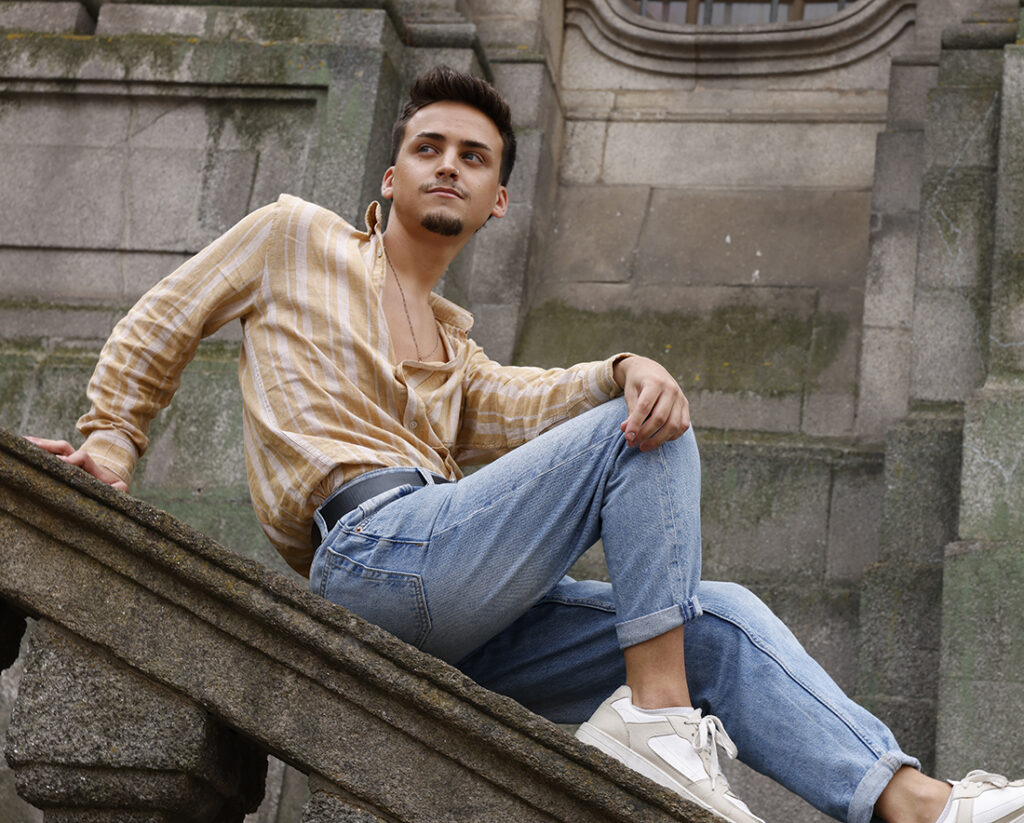 jaunty man with goatee rests on stone bannister