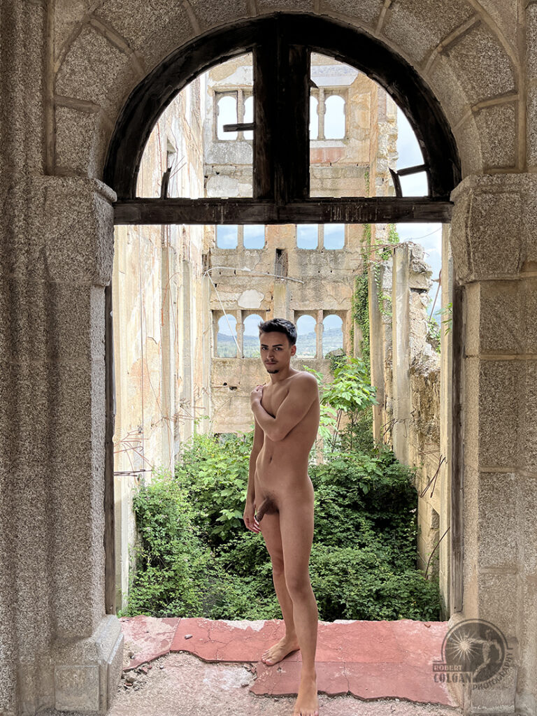 nude man stands in door frame of abandonment