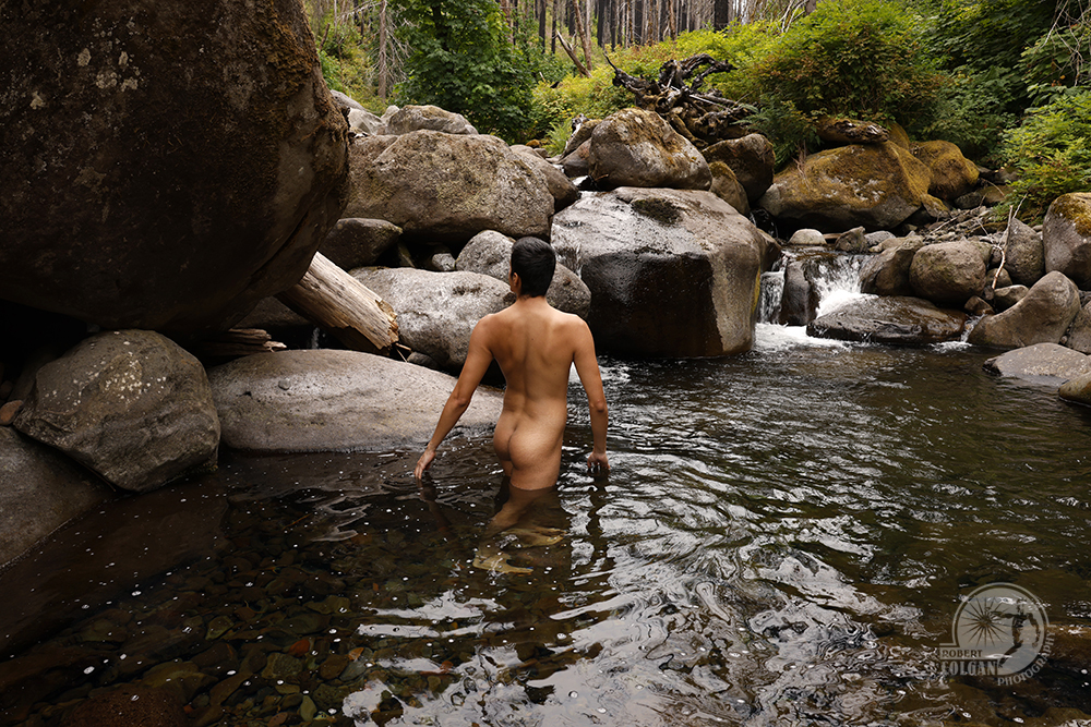 nude man in mountain stream