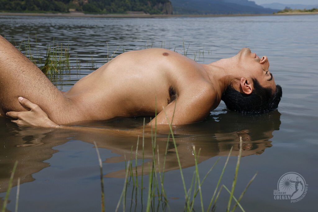 nude man taken from the side with back arched while in river